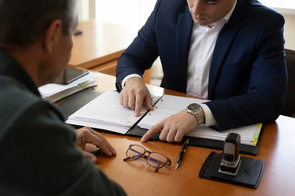 Signing table with a trust binder, notary stamp and pen during an estate planning meeting