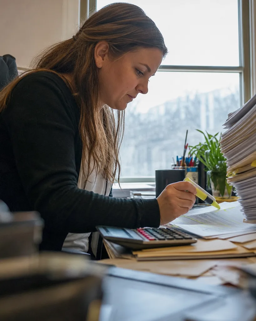 Paralegal highlighting medical bills in a stack of personal injury records